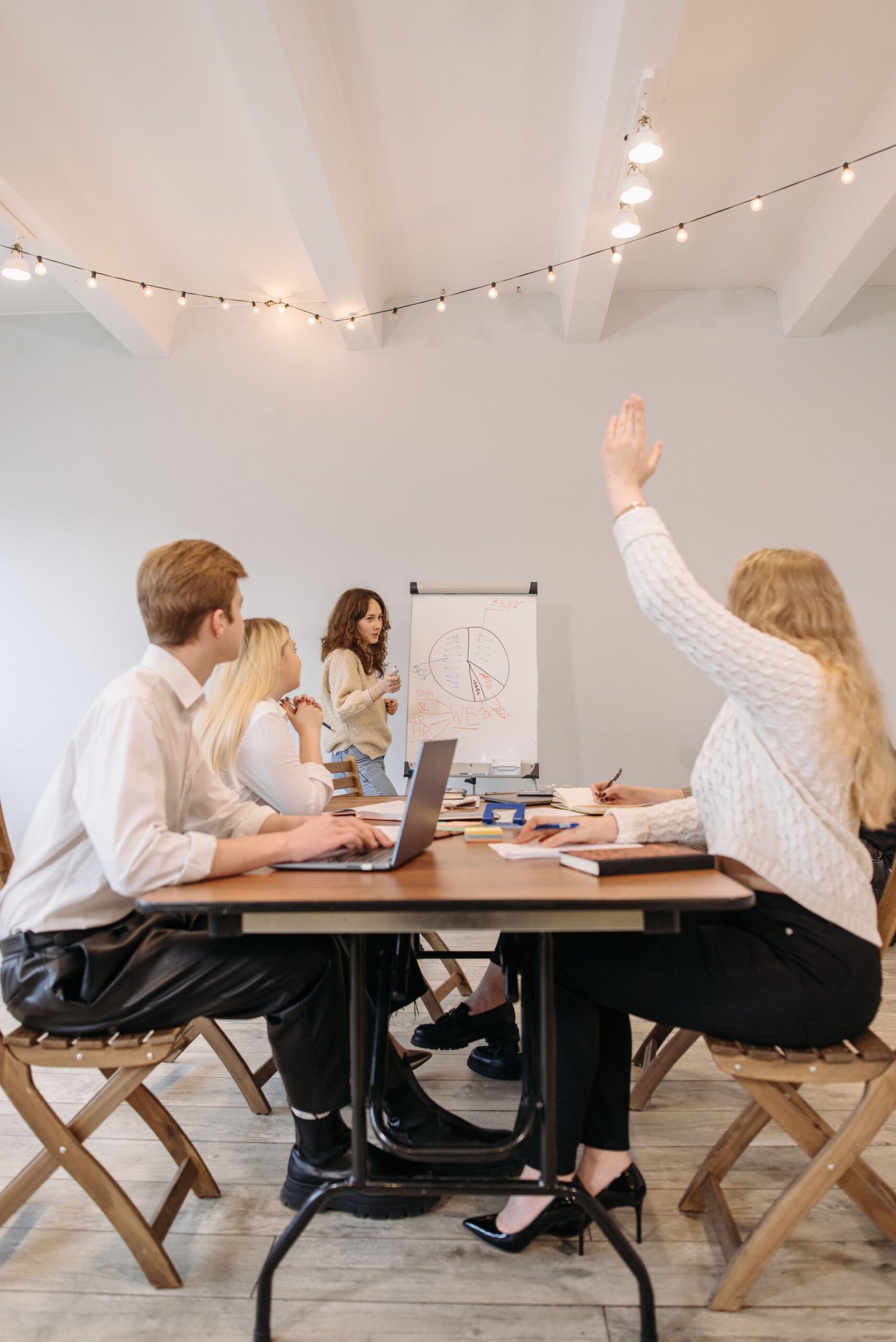 Atelier de formation en entreprise avec une formatrice présentant sur un paperboard et des participants qui échangent